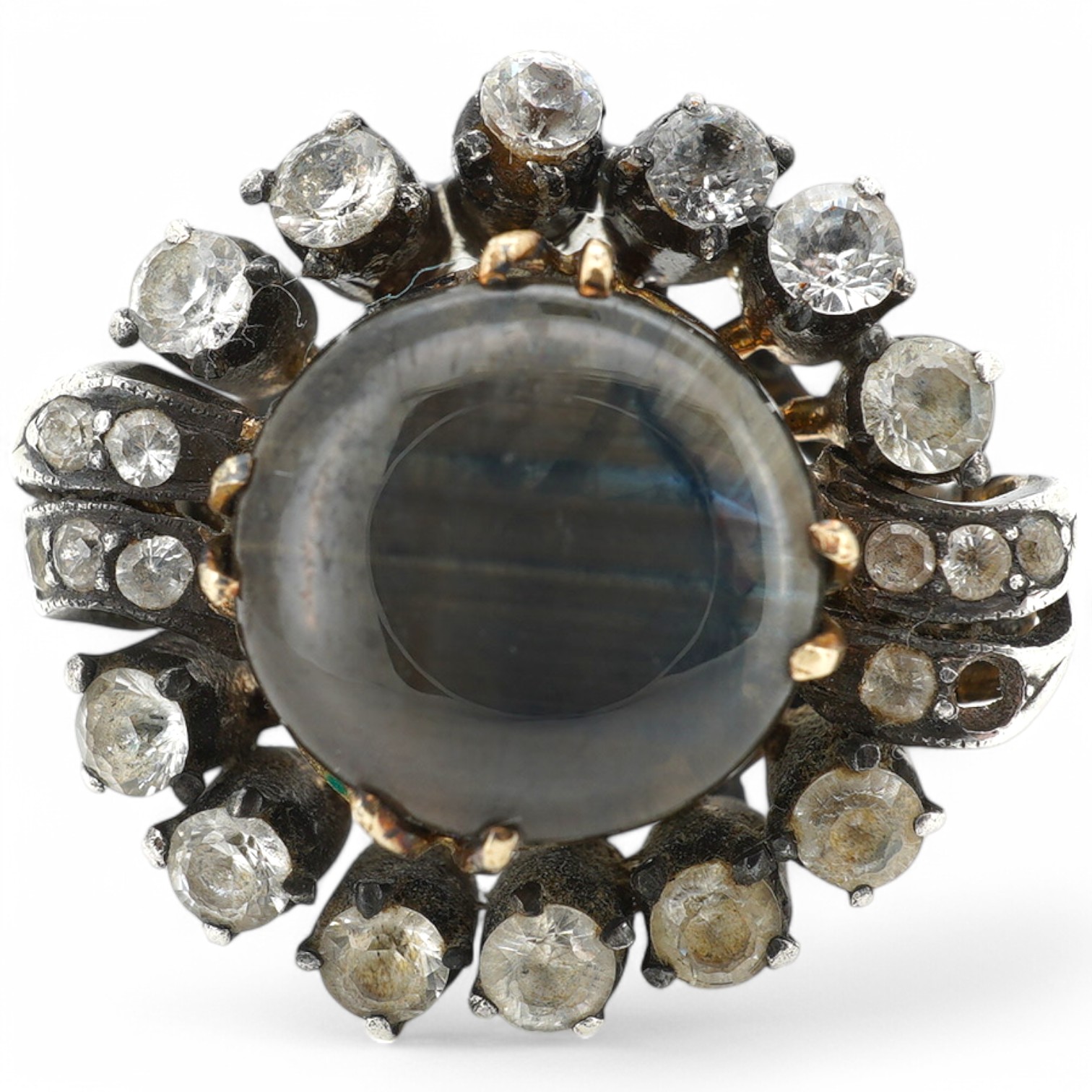 An Indian? yellow and white metal (shank stamped 18k), greyish star sapphire and simulated diamond cluster set dress ring, size O, gross weight 8.2 grams. Condition - poor (stone missing).